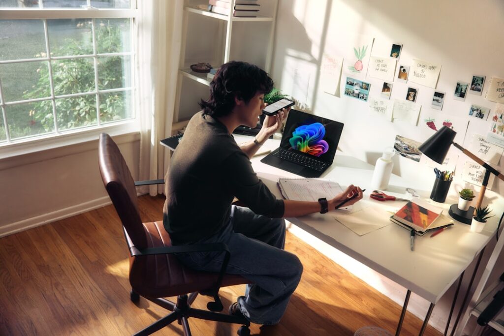 Person working at a desk with a laptop and books.
