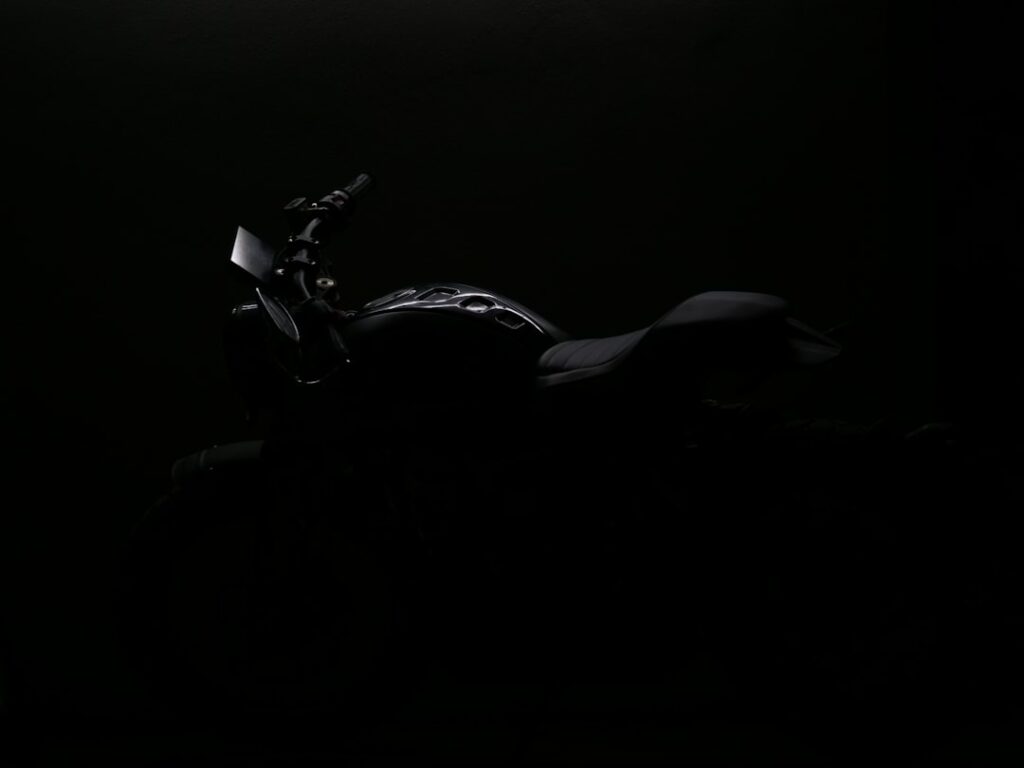a motorcycle is shown in the dark with its headlights on